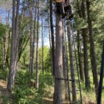 Colton Warren with guitar sitting in a tree stand