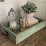 A green table top tray filled with home interior decorations