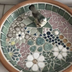 A floral design mosaic tabletop birdbath.