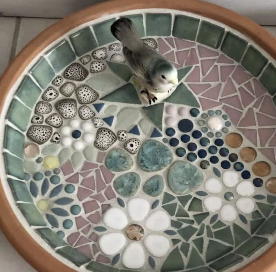 A floral design mosaic tabletop birdbath.