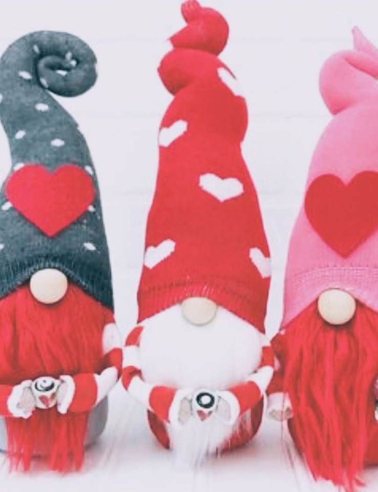 Three gnomes with red and white beards and valentine hats