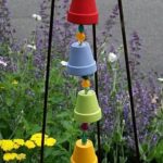 a brightly painted rain chain made of small terra cotta planters