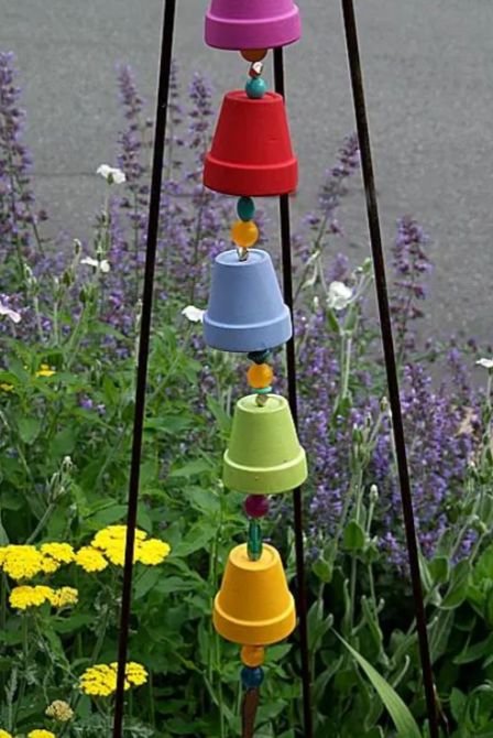 a brightly painted rain chain made of small terra cotta planters
