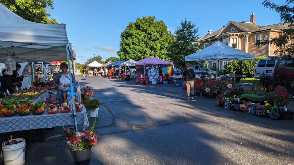 Shoppers peruse booths at the outdoor farmers market