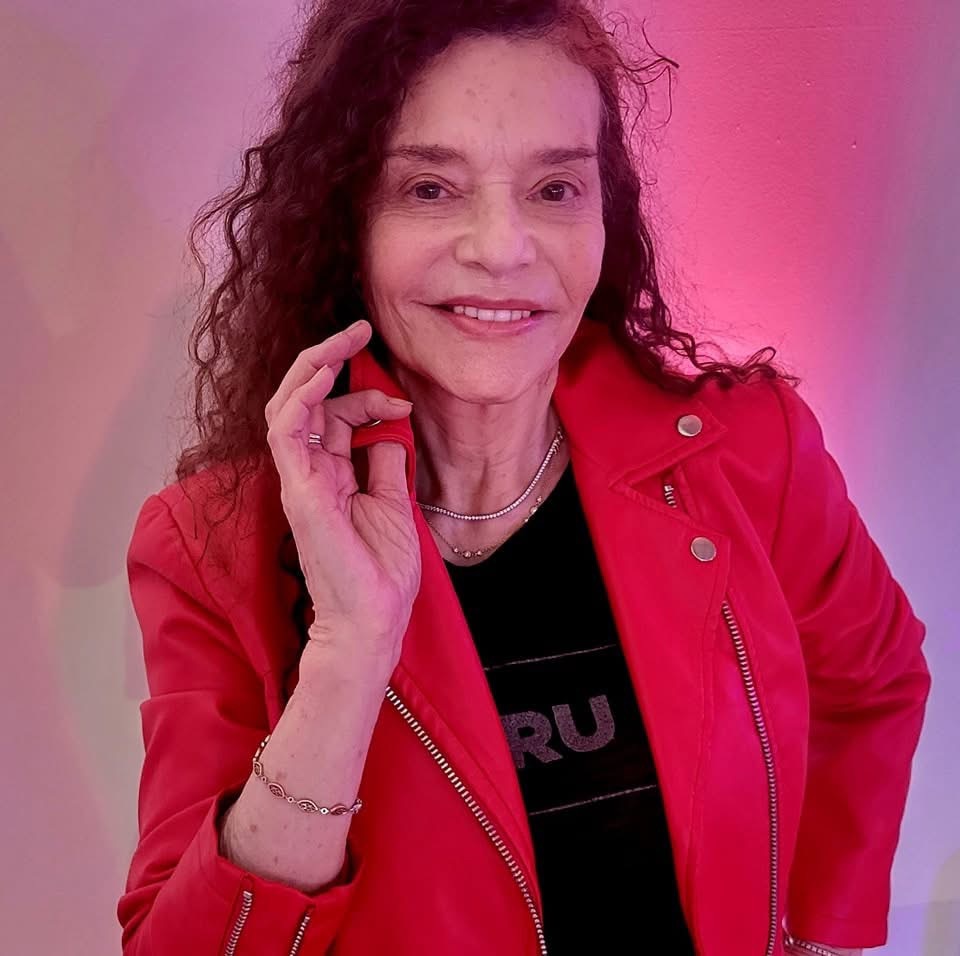 A smiling ruth lordan in a red jacket