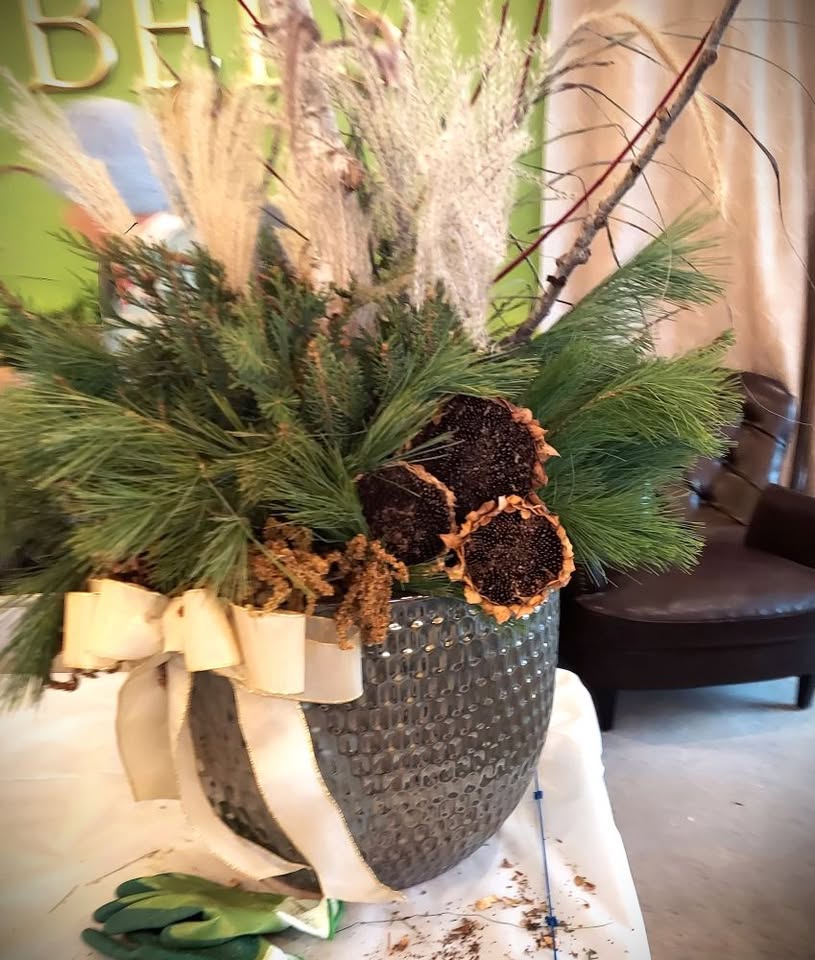 A pot full of evergreen firs and decorations