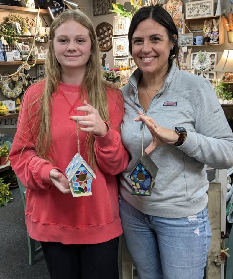 A picture of two woman holding Mosaic Bird House.
