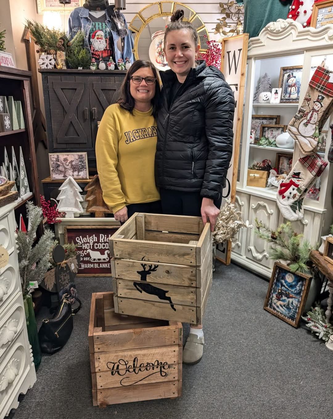 A man and woman standing behind a planter box with a deer on it.