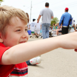 a boy points at a parade