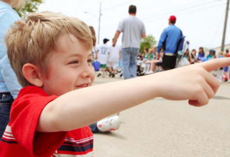 a boy points at a parade