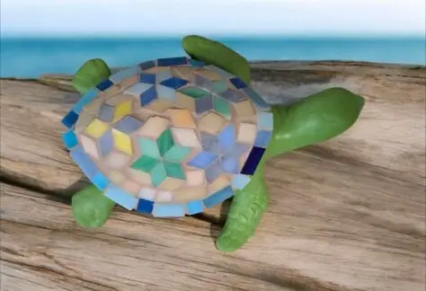 a green garden art turtle with a mosaic shell